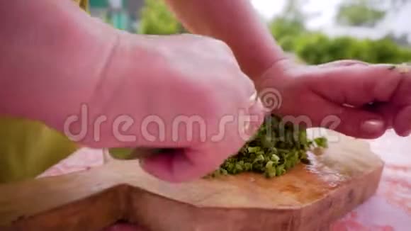 女人用刀切切板上的洋葱压在上面的刀上准备沙拉的过程视频的预览图
