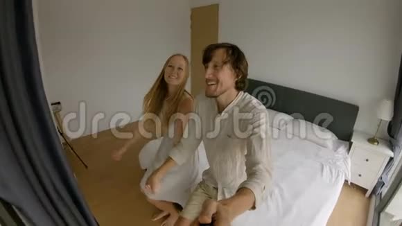 一对幸福的夫妇在床上摔倒的慢镜头旅行概念蜜月概念视频的预览图