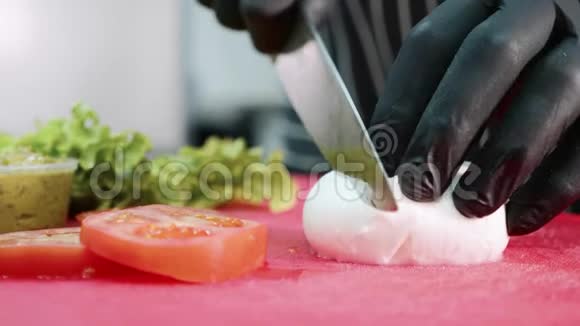 厨师正在蔬菜附近的切割板上切割莫扎雷拉奶酪视频的预览图