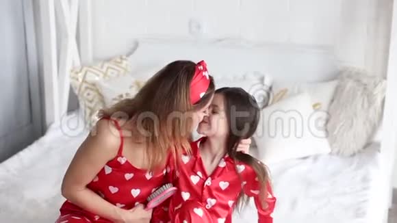 母亲在给女儿梳头时亲吻女儿视频视频的预览图