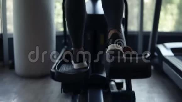 一位漂亮的年轻女子在健身房用黑色运动鞋紧身裤和黑色运动鞋锻炼身体视频的预览图