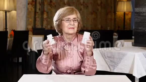 一位老太太在看药品标签快乐健康的生活理念4公里视频的预览图