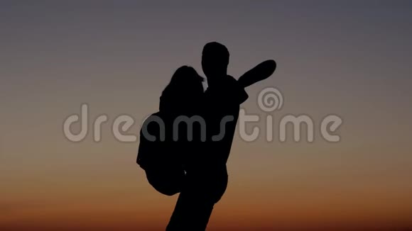 男人手挽手女人在日落的天空中围着她转视频的预览图