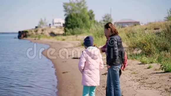 一位年长的妇女和一个成年的女儿沿着河走在河边愉快地交谈着笑着说着视频的预览图