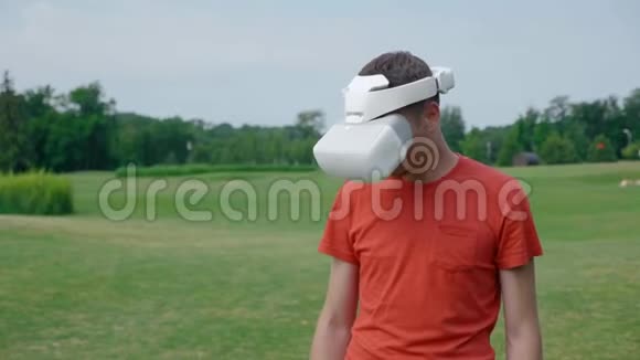 一个男人在公园里用VR耳机把头低下来视频的预览图