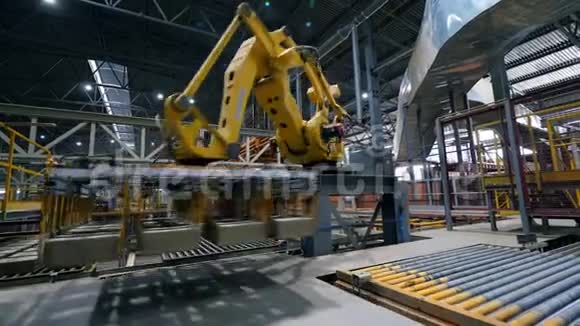 在一家现代化的工厂里工作臂在一条线上移动砖块视频的预览图
