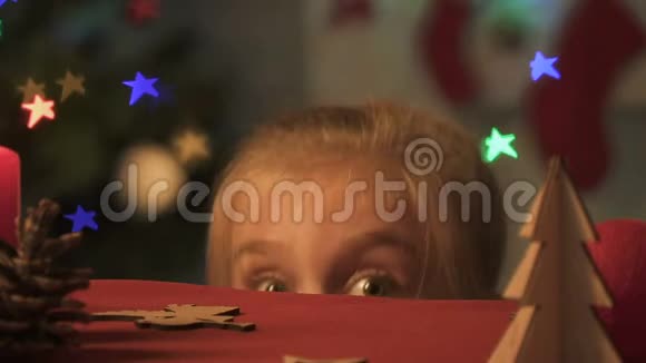 小女孩从桌子底下出现四处张望做圣诞恶作剧视频的预览图