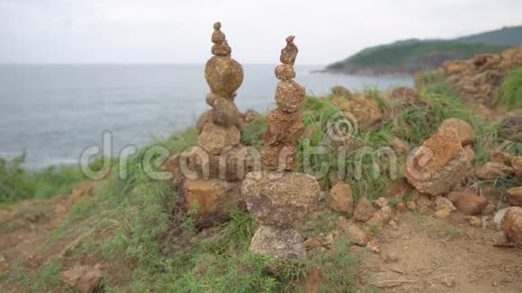 两个凯恩站在高高的岩石上海洋背景下的石堆视频的预览图