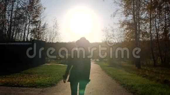 在日落公园一个时髦的女人在镜头前散步夏天欣赏大自然视频的预览图