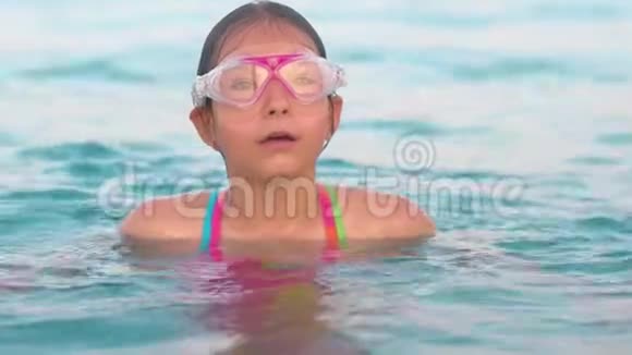 戴潜水面具的孩子嘴里呼吸空气潜入水中视频的预览图