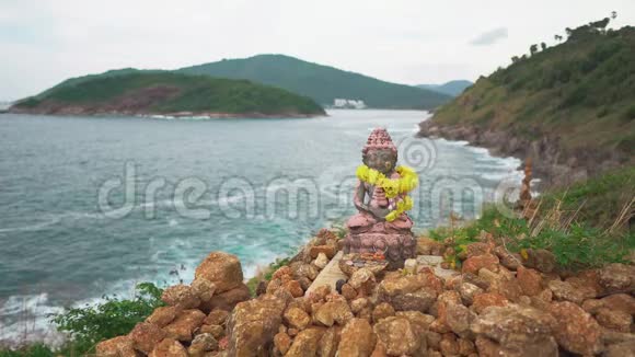 小雕像坐在莲花的位置神在悬崖顶上的海和青山视频的预览图