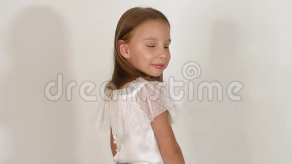 可爱的金发小女孩在工作室的白色背景上摆姿势视频的预览图