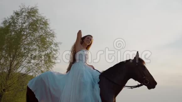 长头发的女孩穿着一件白色的连衣裙在马背上慢动作视频的预览图