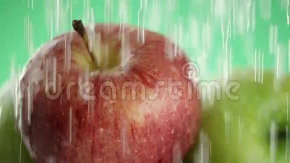 在视频中我们看到苹果水从顶部像雨一样倾泻特写绿色的背景视频的预览图