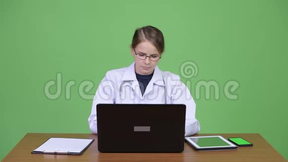 年轻有压力的女医生在木桌旁工作看上去很累视频的预览图