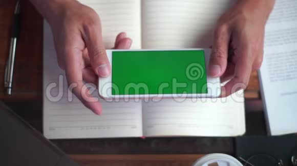 紧紧抓住一个男人手握着手机看着绿色屏幕互联网技术和智能手机概念视频的预览图