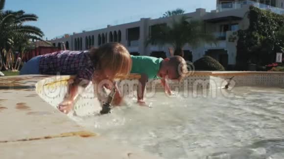 男孩和女孩在喷泉中飞溅视频的预览图