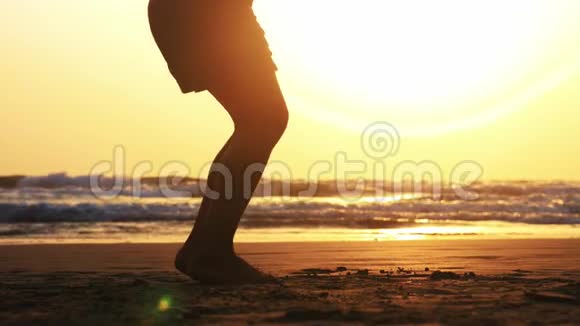 日落时分在海边沙滩上女孩双腿在绳子上跳跃视频的预览图