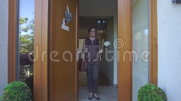 一个穿棕色T恤的女人站在门口视频的预览图