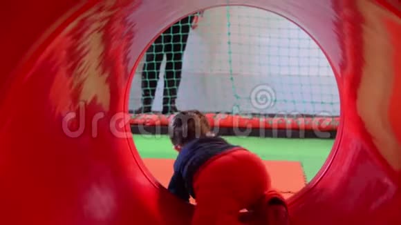 幼儿在游戏区从红色的隧道里走出来视频的预览图
