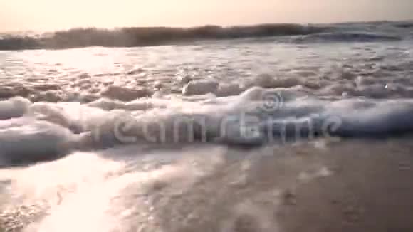 海浪泡沫到达相机回到大海海浪蓝天的背景视频的预览图