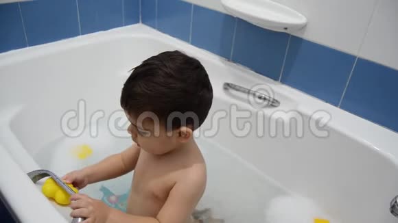 幼儿在玩玩具在浴缸里用泡沫洗澡视频的预览图