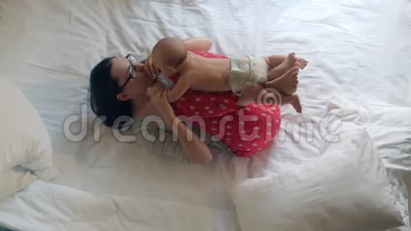 新生儿躺在母亲的腿上宝宝锻炼家中儿童护理视频的预览图