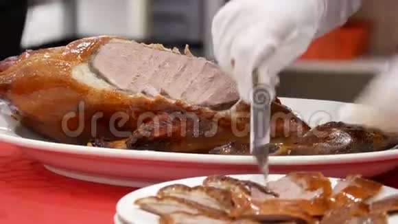中餐厅内厨师将烤鸭切成盘子的动作视频的预览图