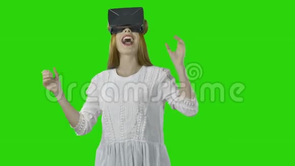 一个戴着3D眼镜的年轻女孩正在观看虚拟现实用她的手和嘴唇做手势表达积极的情绪视频的预览图