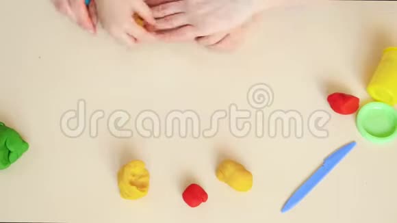 快乐的妈妈和孩子特写手玩数字从塑料面团混合模型俯视视频的预览图