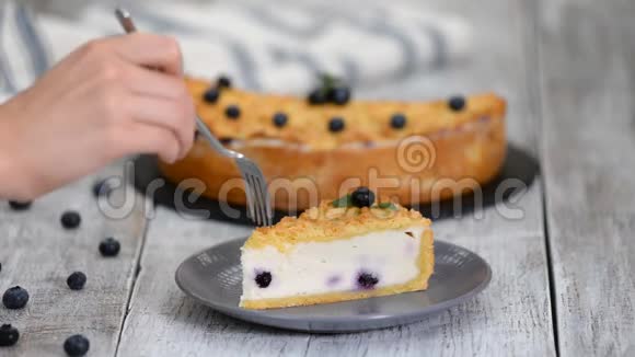 女人吃美味的芝士蛋糕和蓝莓视频的预览图