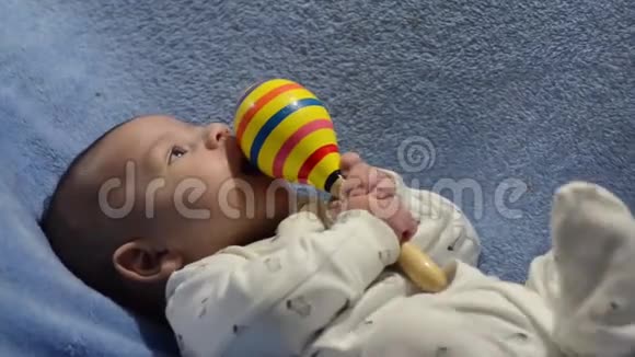 大树几个月大的刚出生的小男孩抱着马拉卡斯想咬它视频的预览图