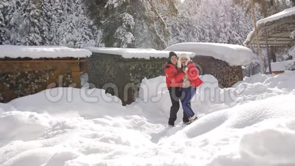 在清晨的阳光下幸福的一对夫妇在山上靠近冬天的Chalet视频的预览图