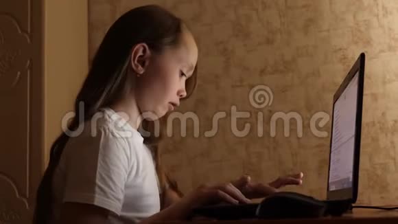 女孩通过拨打搜索查询和微笑在笔记本电脑上做作业网上电脑游戏视频的预览图