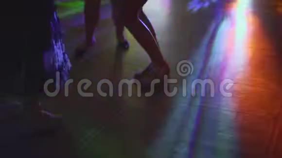 拉丁萨尔萨派对上跳舞的人们腿的剪影有多种颜色的彩虹灯跳舞的腿视频的预览图
