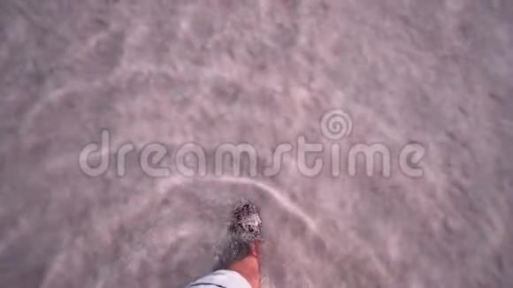 沿着盐湖散步的游客的腿视频的预览图