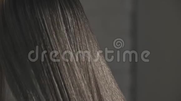 在发廊里一个女人在缓慢的动作中把头发理直视频的预览图