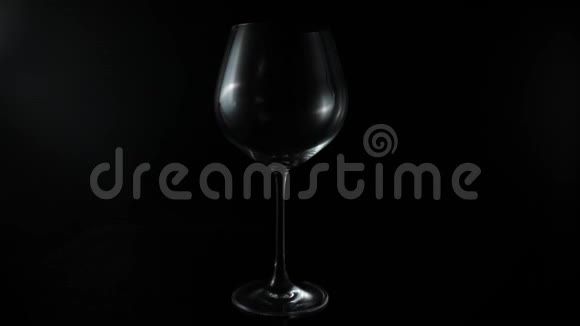 在黑色背景上的玻璃杯上倒入红酒视频的预览图