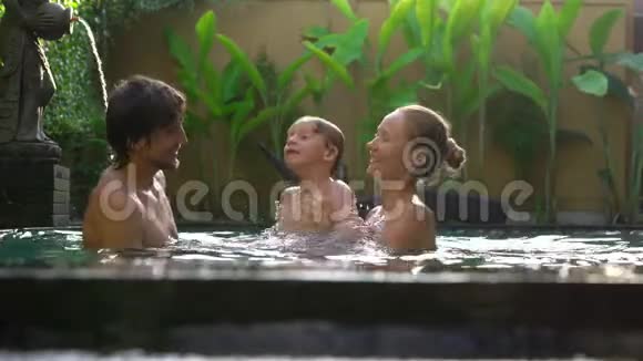 幸福的家庭父子俩在游泳池里玩得开心视频的预览图