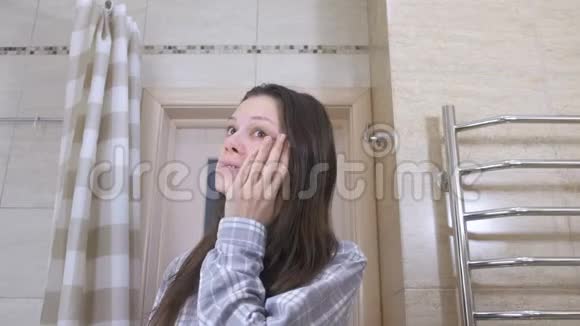 疲惫的女人在浴室里看着她在恐怖中的倒影试图使自己井井有条视频的预览图