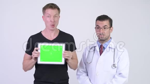 西班牙籍男子医生带着年轻的疯狂病人展示数字平板电脑视频的预览图