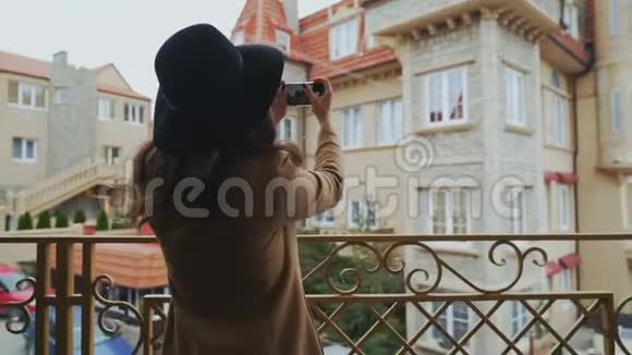 从后面看特写镜头穿着外套和帽子的斯特迪坎苗条的女人在城市里走来走去拍了一张照片视频的预览图