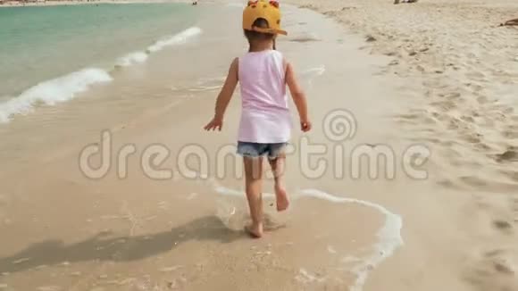 小可爱的女孩在海滩上奔跑视频的预览图