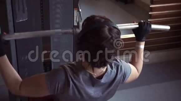 带耳机的布鲁内特做背部肌肉锻炼视频的预览图