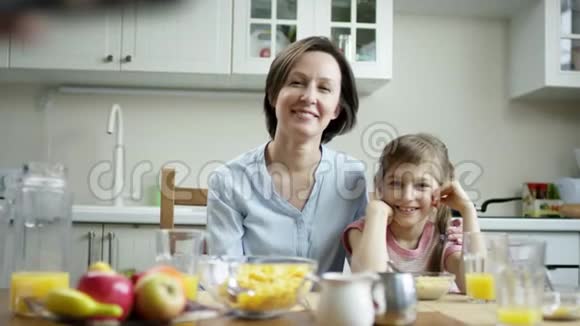 镜头显示有人用流动镜头在电话里拍母亲和女儿的照片视频的预览图