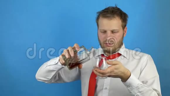 一个酒鬼留着白衬衫和领带的胡子把酒精白兰地从瓶子里倒进杯子里然后喝视频的预览图