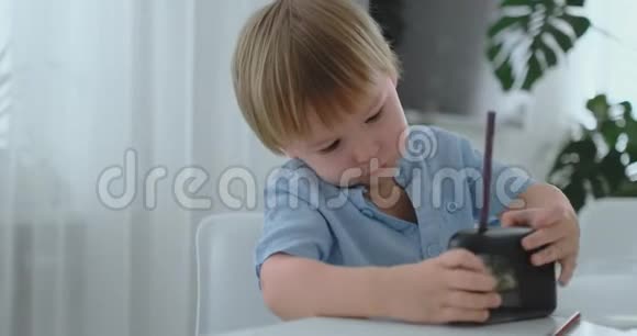 坐在桌旁磨铅笔的男孩视频的预览图