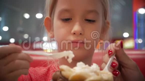 年轻的母女在咖啡馆里吃冰淇淋良好的亲子关系一起度过快乐时光家庭视频的预览图