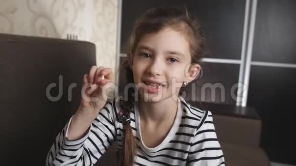 小女孩为掉下来的牙齿高兴小女孩的肖像出现在相机掉落的婴儿牙齿上视频的预览图