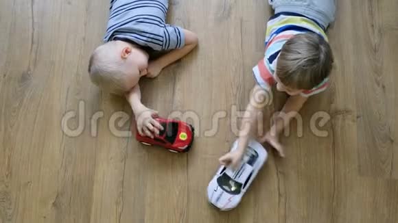 家庭观念男孩在木地板上玩汽车直接上图视频的预览图